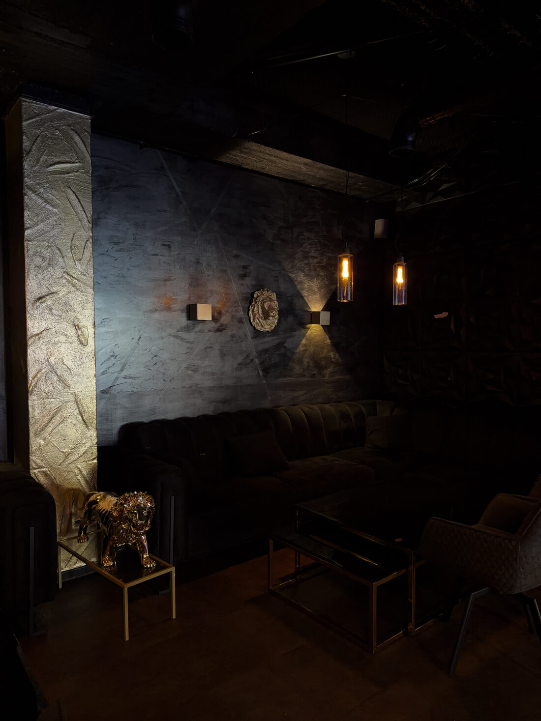 Dunkle Lounge mit goldenem Löwen und Chesterfield-Sofa